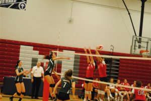 Senior captain, Genna Luciano, hits the ball over two blockers for the kill. 