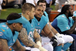 Miami Dolphins guard Richie Incognito (68), second from left,  and tackle Jonathan Martin (71), third from left, sit on the bench in the second half of an NFL football game on Sept. 30, 2013. (AP Photo/Bill Feig, File)