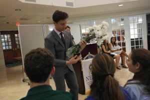 NEHS president, Ian Schneider, handing out flowers. (via Alex Lee, senior) 