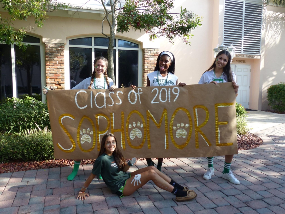 Libby Baker, Ashleigh Clark, Natalie Klarr, and Hannah Sternthal pose with the sign they made for the Homecoming Pep Rally.
